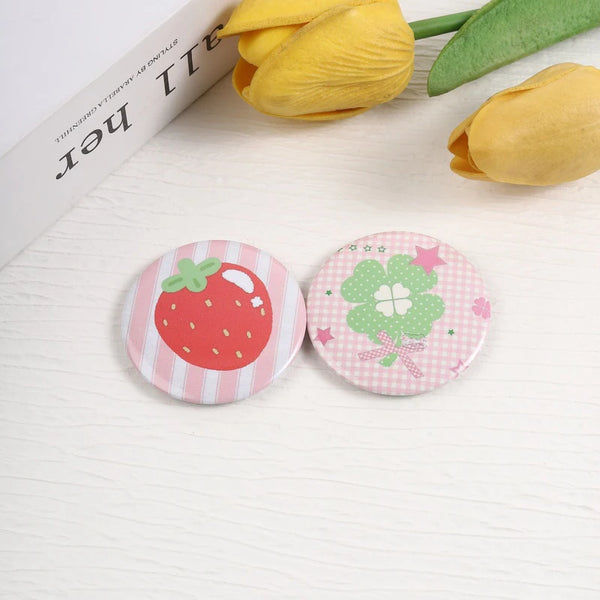 A set of funny tinplate pin brooches featuring strawberry and clover designs.