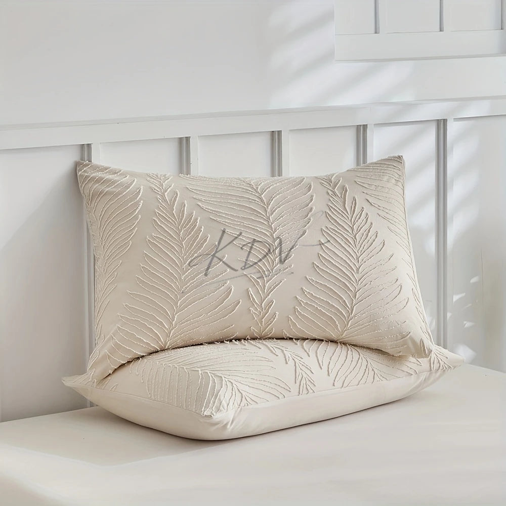 A beige embossed leaf duvet cover pillow resting on a white surface.