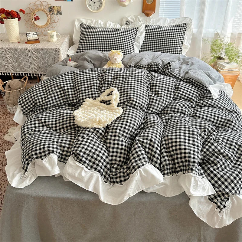 A plaid duvet cover set featuring black and white gingham fabric with lace embroidery on a bed.