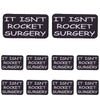 Two black embroidered patches with the text IT ISN'T ROCKET SURGERY