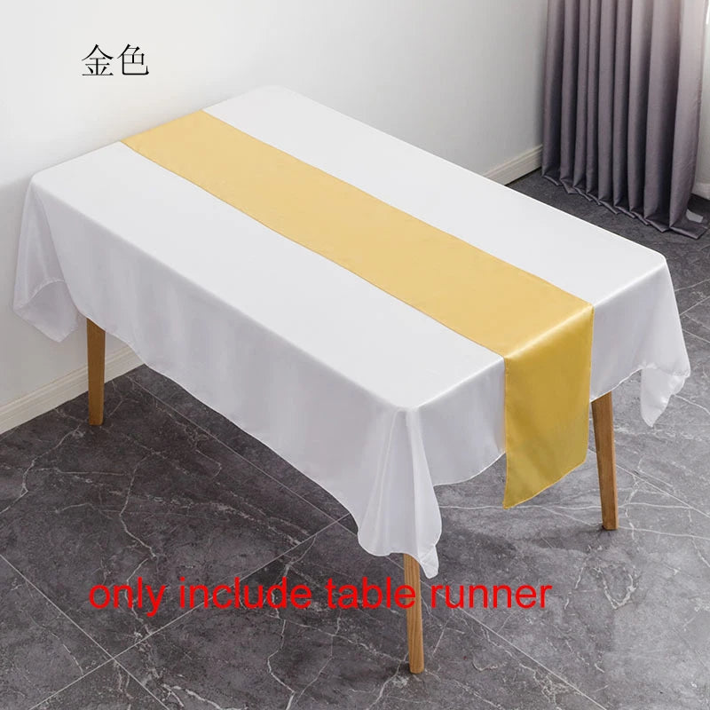 A white tablecloth with a yellow satin table runner is displayed on a wooden table.