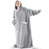 A person wearing a oversized gray flannel blanket pyjama set with a hood.