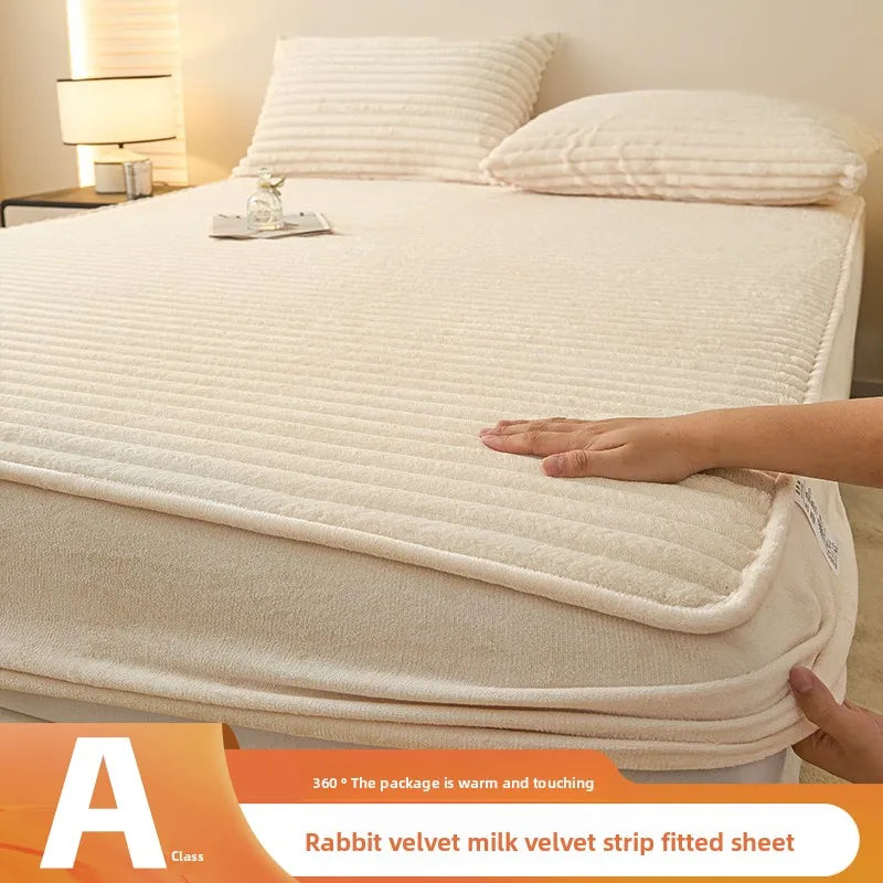 A rabbit velvet milk velvet strip fitted sheet is shown on a bed, with a hand adjusting the sheet.