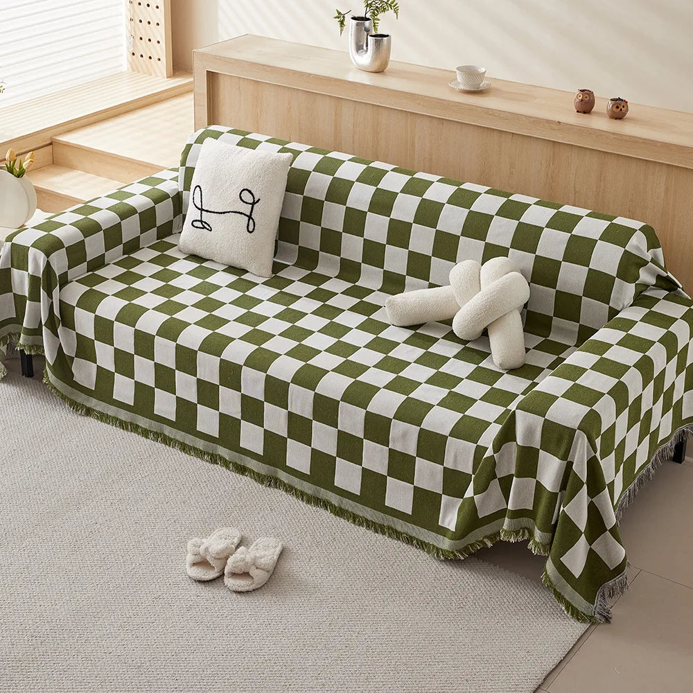 A green and white checkerboard sofa slipcover draped on a light rug.