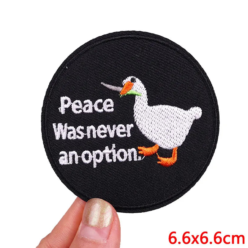 Black embroidered patch featuring a white duck with orange feet and text that reads Peace Was never an option