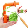 A hand holds an orange crochet tool and a green crocheted item, demonstrating a tension regulator set.