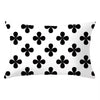 A white decorative pillow cover featuring a repeating pattern of black four-leaf clovers.