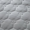 Light gray quilted fabric texture showing a repeating hexagonal pattern.