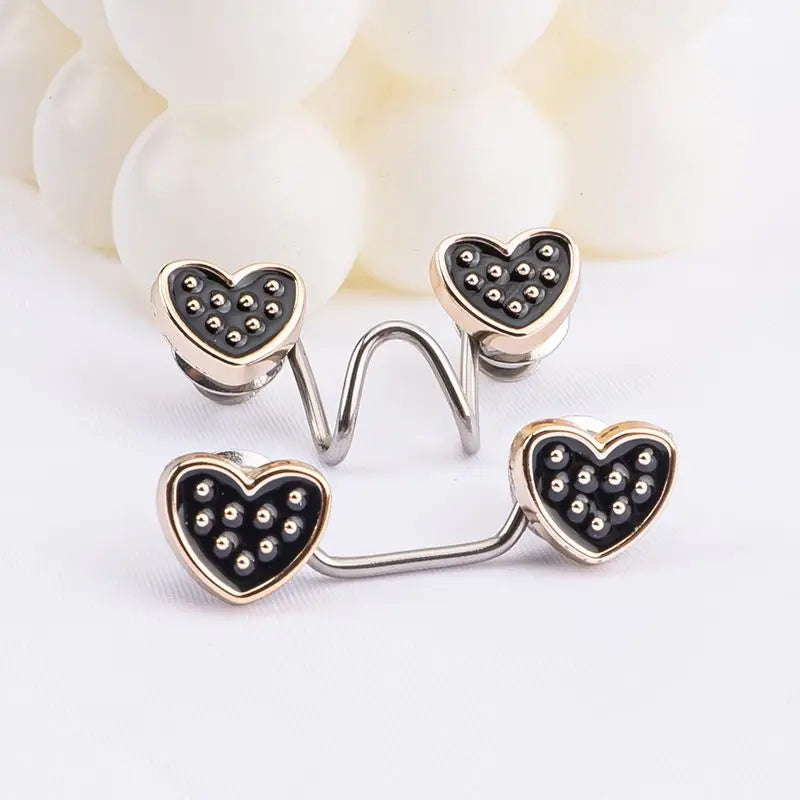 Silver heart-shaped button clips with black studs used for adjusting jeans waist tightness