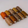 A collection of ten rolls of high-quality polyester sewing thread in various shades of brown and orange.