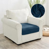 A cream upholstered armchair with navy blue seat covers and a dark blue decorative throw.