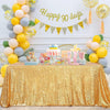 A gold sequin rectangle table cover is displayed on a table, decorated with balloons and a banner reading Happy 30 days.