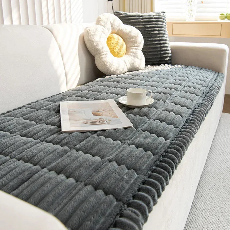 A gray corduroy sofa armrest cover with a yellow decorative cushion and a small cup on the surface.