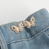 Gold glitter butterfly button clips attached to a denim fabric