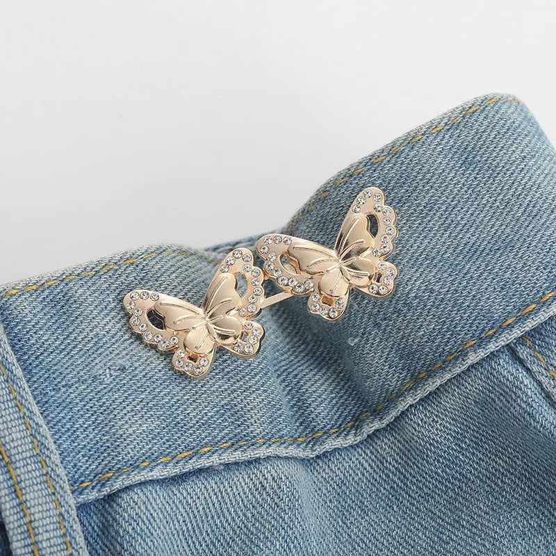 Gold glitter butterfly button clips attached to a denim fabric