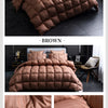 Brown quilted duvet blanket displayed on a bed, showing the texture and high down fill.