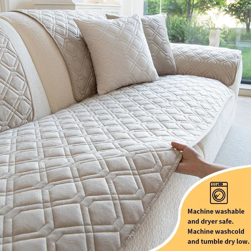 A beige quilted sofa cushion cover with a diamond pattern shown on a light-colored sofa.