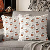 White throw pillow cover featuring a pattern of small ghost and pumpkin designs on a gray sofa.