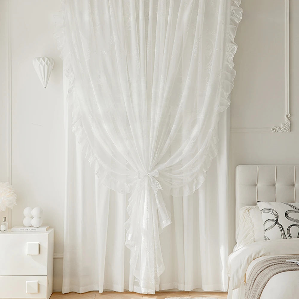 White vintage ruffled lace embroidered curtain hanging in a bright room.