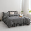 A black and white plaid duvet cover set with a solid cream pillow on a bed.
