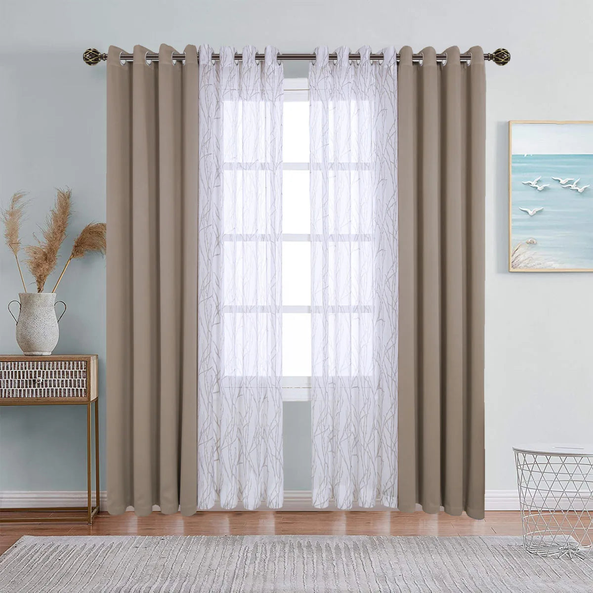 A set of beige sheer and blackout window drapes hanging on a rod in a light blue room.