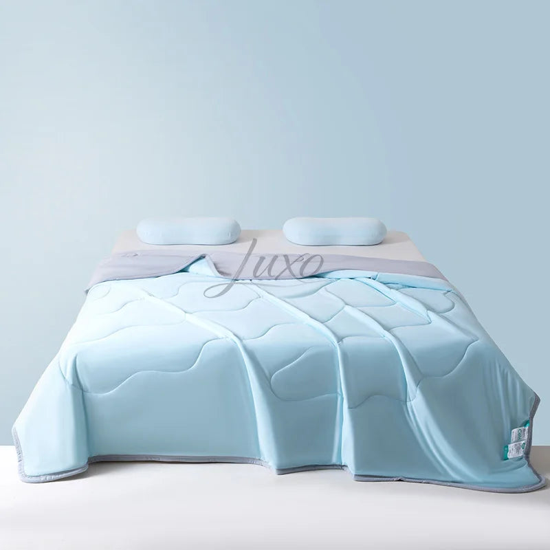 Light blue ice silk summer cooling blanket folded on a bed