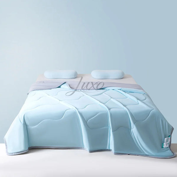 Light blue ice silk summer cooling blanket folded on a bed