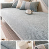 A woven sofa cushion cover in gray and beige tones with decorative piping, shown on a sofa.