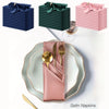 A set of silky satin dinner napkins in various shades of blue, green, and pink are displayed on a white surface.