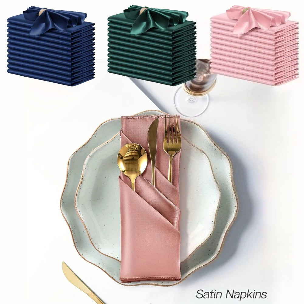 A set of silky satin dinner napkins in various shades of blue, green, and pink are displayed on a white surface.