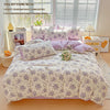 A lavender print duvet cover set with pillowcases displayed on a bed, next to a window and bedside tables.