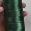 A spool of dark green high tenacity polyester sewing thread with a yellow plastic core.