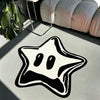 A black pentagram rug is placed on a light surface next to a potted green plant and a beige upholstered cushion.