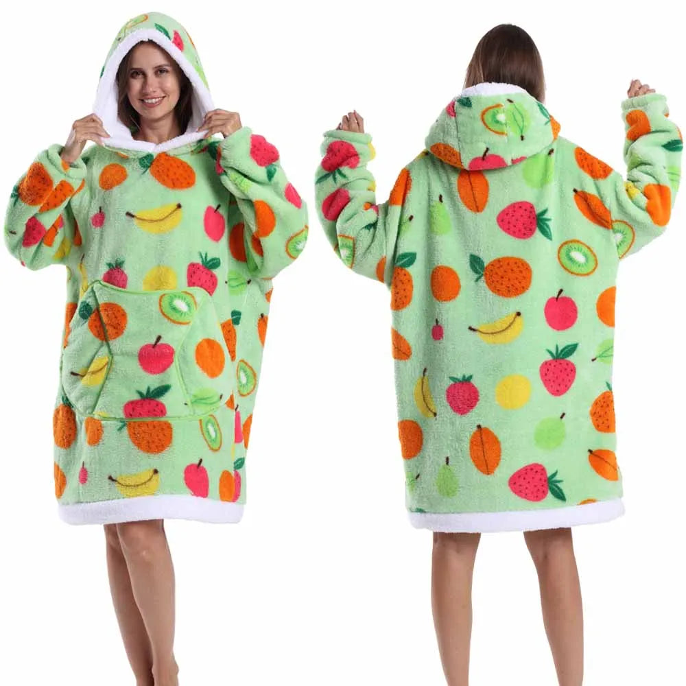 A person models a light green patchwork fleece hoodie with colorful fruit patterns.
