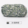 A ball of hand-dyed fabric strip yarn featuring a mottled green and beige pattern.
