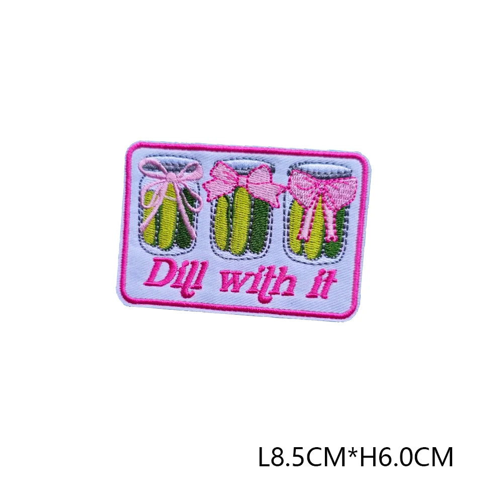 Pink and green embroidered letter patch with the text Dill with it