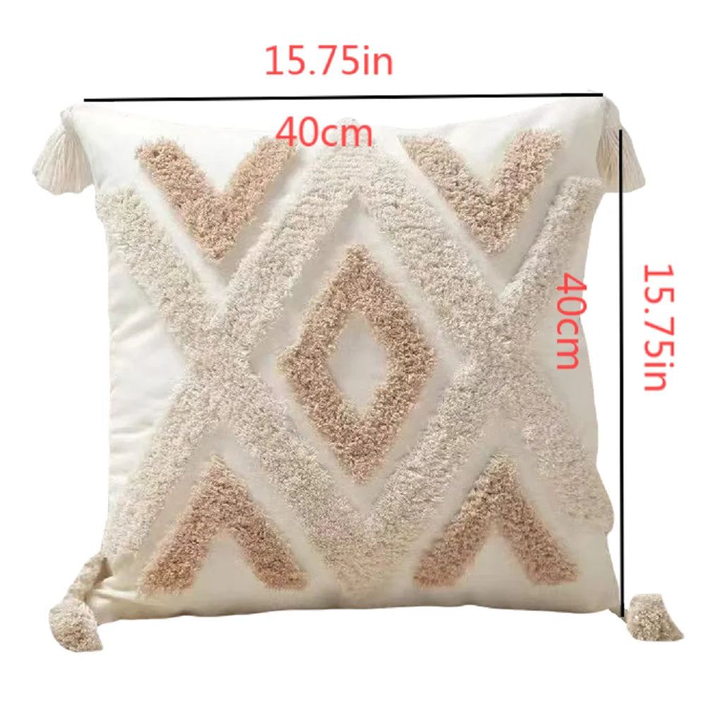 A square plush pillow cover in cream color featuring a geometric chevron pattern with light brown faux fur and tassel details