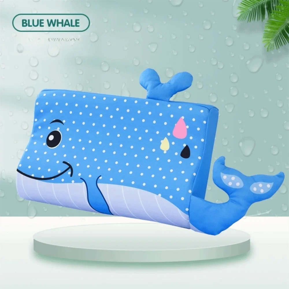A blue whale shaped memory foam neck pillow for toddlers resting on a white surface.