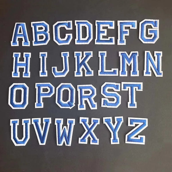 A set of blue alphabet embroidery iron-on patches showing the letters A through Z.