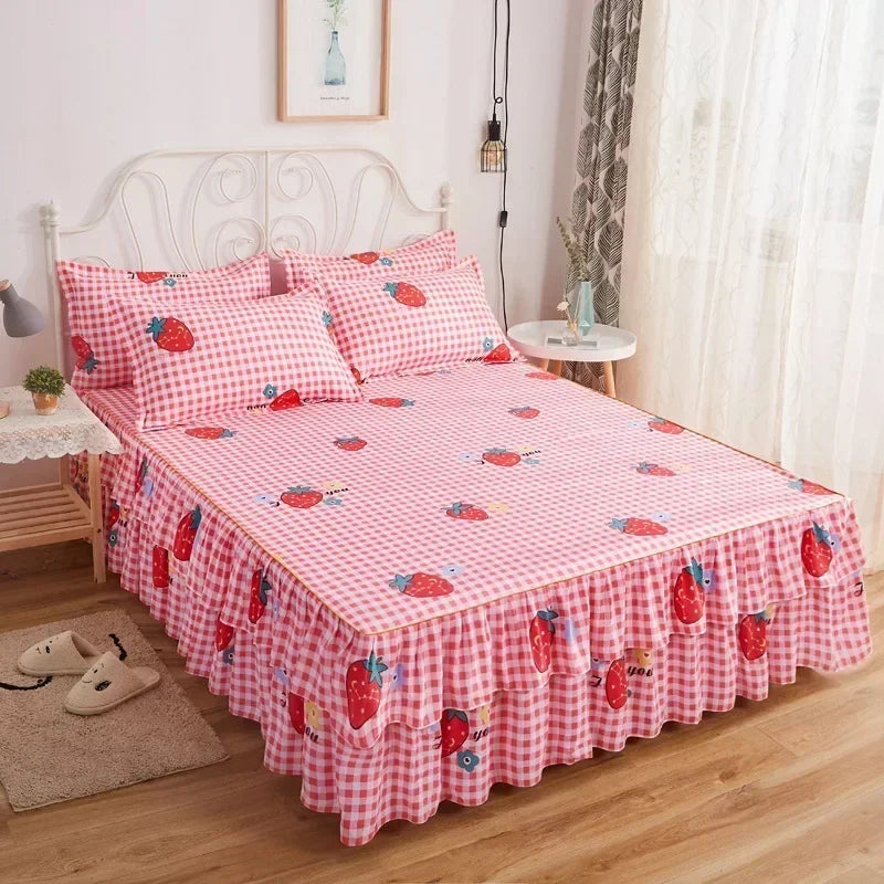A pink and white checkered bed skirt with strawberry patterns on a white metal bed frame.