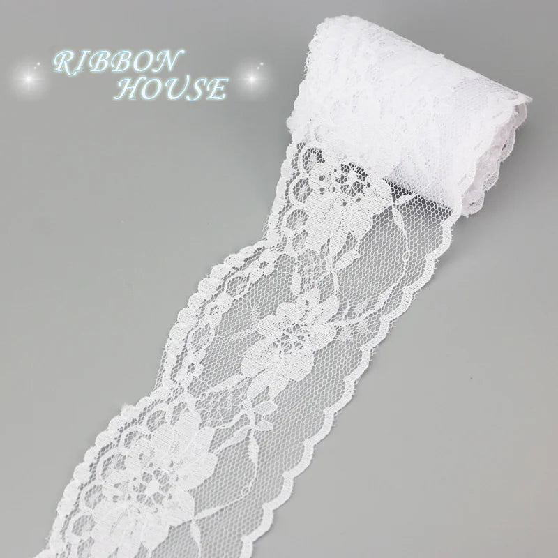 A roll of white decorative lace ribbon for a house, featuring floral patterns.