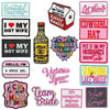 A collection of embroidered iron-on clothing patches featuring various text designs like I love my hot wife and Let them.