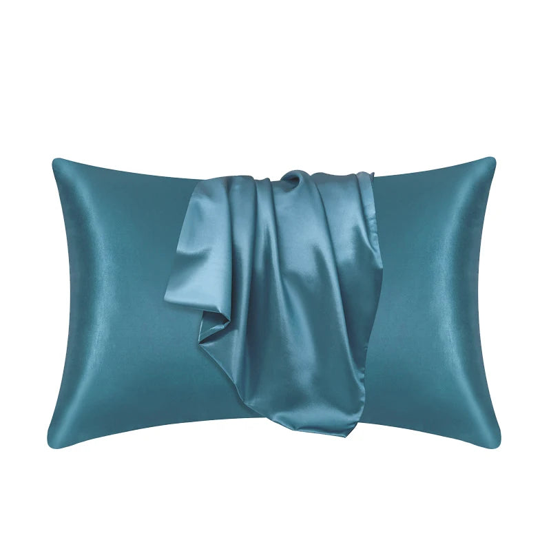 A teal satin silk pillow cover with a draped fabric detail.