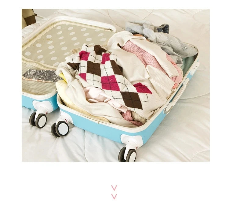 A light blue travel organizer storage set with a lid is shown open, filled with folded clothing and accessories on a white be