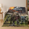 A blanket featuring a Jurassic World dinosaur graphic on a light-colored sofa.