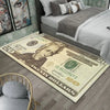 A close-up of a large dollar print anti-slip area rug placed on a wooden floor next to a bed.