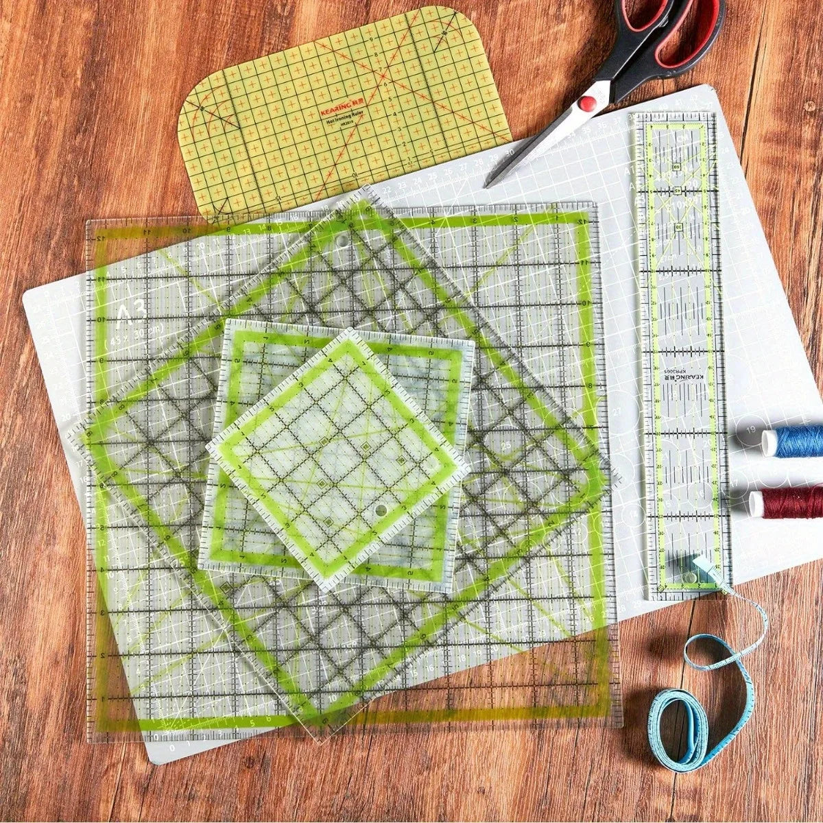 A set of acrylic quilting rulers and an ironing ruler laid out on a wooden surface.