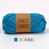 A skein of bright turquoise yarn labeled Sweet Candy Yarns with a brown label.