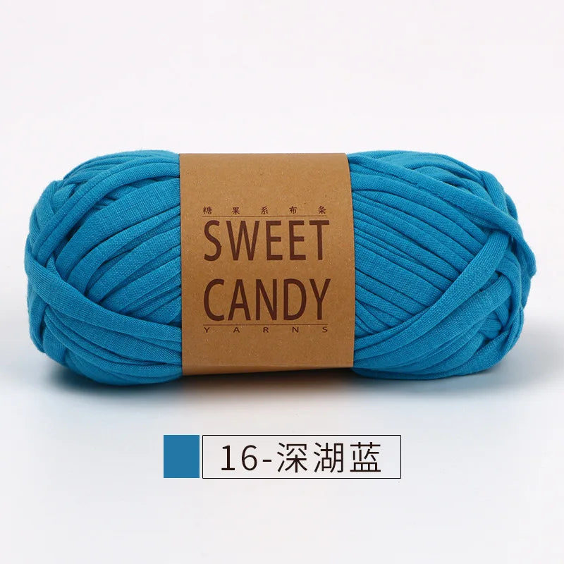 A skein of bright turquoise yarn labeled Sweet Candy Yarns with a brown label.