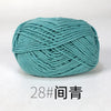 A ball of teal organic cotton 4ply knitting yarn labeled as size 28